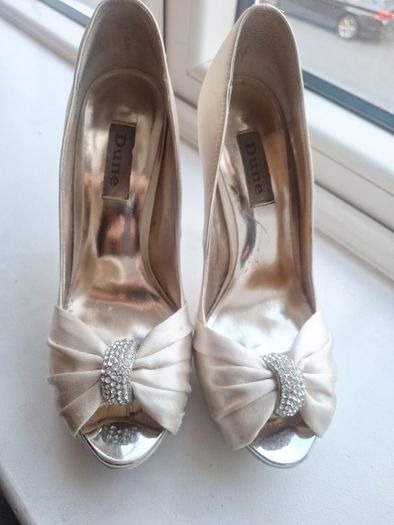 Ivory satin peetoe high heel shoes by Dune London with a pleated bow trim accented with rhinestones