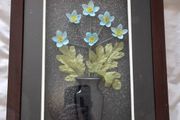 Framed arrangement of plastic flowers