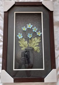 Framed arrangement of plastic flowers