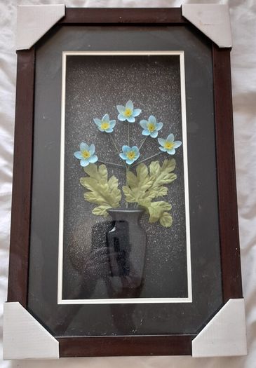 Framed arrangement of plastic flowers