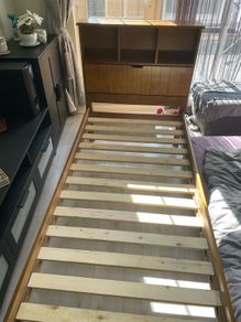 single wooden bed with storage headboard and matress