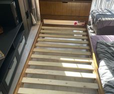 single wooden bed with storage headboard and matress