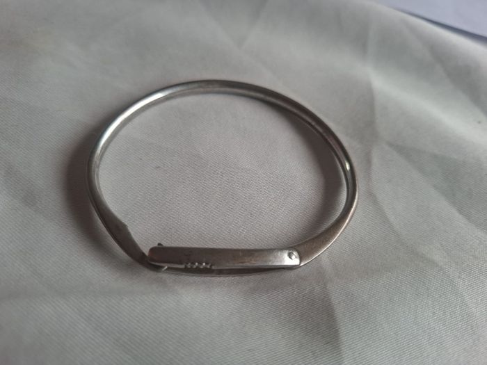 Sculptural sterling silver bangle with three tiny diamond accents.