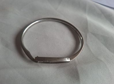 Sculptural sterling silver bangle with three tiny diamond accents.