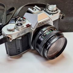 Canon AV-1 35mm SLR Film Camera with Canon FD 50mm f1.8 Lens & Hoya Filter (Pre-owned, SilverBlack)