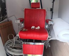 Beautiful red vintage Barbers chair with white piping