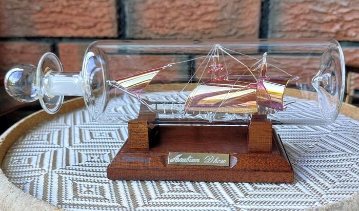 Blown Glass "Arabian Dhow" Sailing Ship Housed in Clear Glass Bottle.