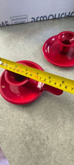 Set of 2  Red enamel candlestick holder and drip tray featuring a Considered by Helen James 12.00 euro each.