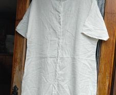 Off white linen button-down  longline tunic featuring a relaxed, oversized silhouette.