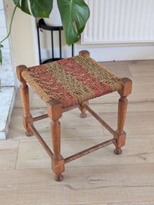 Antique wooden footstool with woven seat