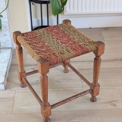 Antique wooden footstool with woven seat