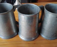 Three antique pewter glass bottomed mugs