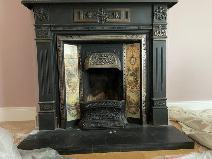Late Victorian / early Edwardian style cast iron fireplace with tiled inserts and a decorative mantel surround