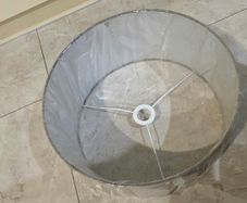 Brand new grey drum lampshade still sealed in its original plastic wrapping.