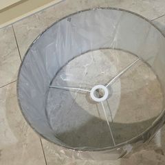 Brand new grey drum lampshade still sealed in its original plastic wrapping.