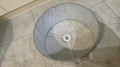 Brand new grey drum lampshade still sealed in its original plastic wrapping.