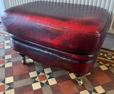 Leather Footstool on brass Castors.