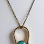 Vintage necklace features a polished, knocker-shaped pendant  gold plated, centered with an iridescent turquoise Spinning Fob Image 2