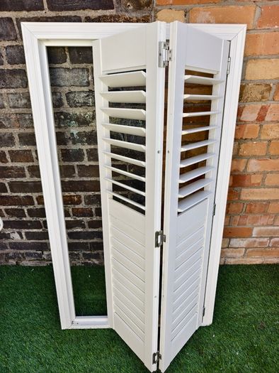 Vintage-style louvered white internal window shutter
