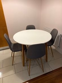 Round dining table with four grey fabric chairs