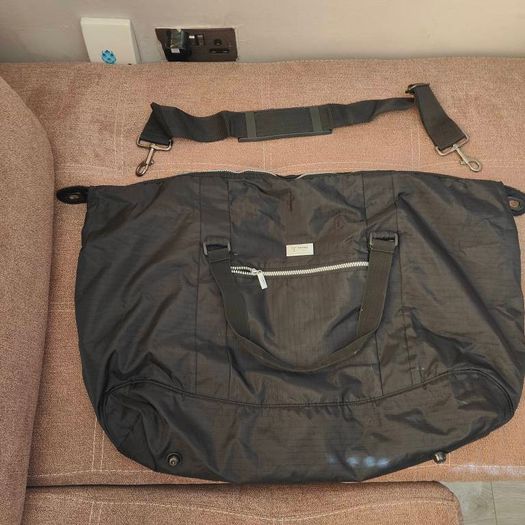 Large black expandable travel bag with shoulder strap