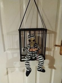 Halloween decorations. Freak in a cage.