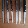 A 12-piece stainless steel steak knife and fork set with wooden riveted handles. Image 5