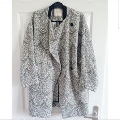Maje black and white Gadget coat. Mid-weight cotton-jacquard. Front slit pockets, goat trim, fully lined. Asymmetric button fastenings through front. 79% cotton