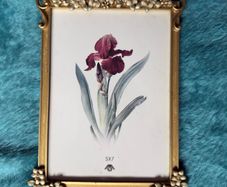 gold-toned metal 5x7 picture frame with decorative floral embellishments.