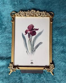 gold-toned metal 5x7 picture frame with decorative floral embellishments.