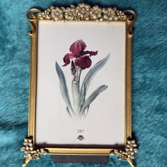 gold-toned metal 5x7 picture frame with decorative floral embellishments.
