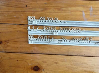 Three white plastic curtain rails