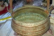 Antique Copper Cauldron features a Rustic Patina, a Swing Handle, and Distinctive Ribbed Detailing around the Rim. It resembles vintage metal pots often used for hearth decoration or as Planters. The piece shows significant oxidation and aging, characteri