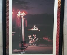 Framed Motivational Attitude Photo showing ambulance crew working on patient on trolley with ambulance in foreground.