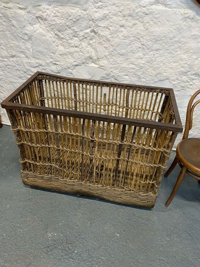 Large Victorian cane and metal laundry basket on wheels.
