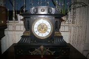 Victorian French Black Slate Mantle Clock (Very large and heavy) with bronze ornamentation Oversized. Open escarpment slate plate Roman numerals. Circa 1890s. Accented with Trojan head. Flanked by two Hellenistic ladies heads on sides. Rose cartouche mask