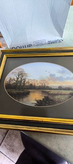VINTAGE Framed landscape print featuring an oval matte aperture with a golden sunset or sunrise over a river, bare trees, and two birds flying in the sky.