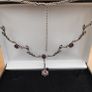 Silver tone floral necklace with red gemstone style accents Image 2