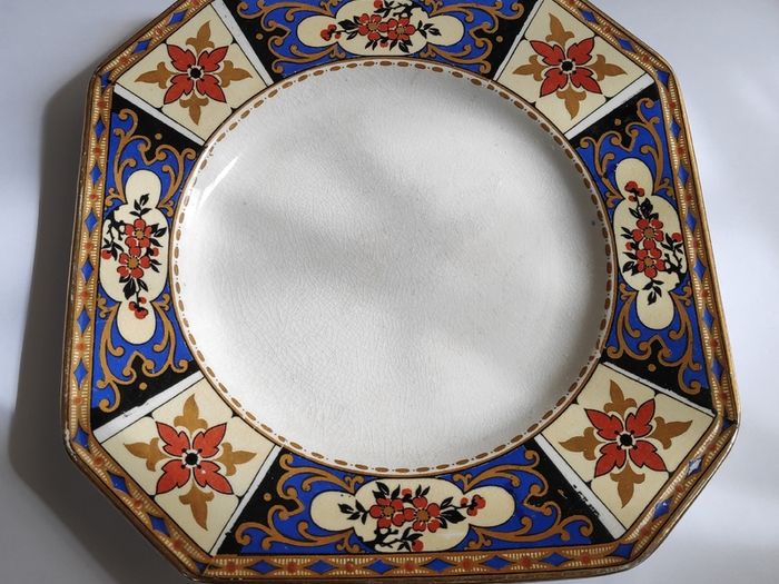 Antique small octagonal plate with floral pattern in blue, red and ochre tones