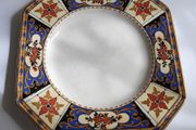 Antique small octagonal plate with floral pattern in blue, red and ochre tones
