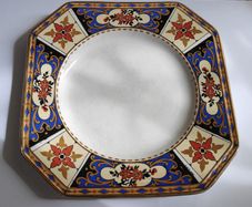 Antique small octagonal plate with floral pattern in blue, red and ochre tones