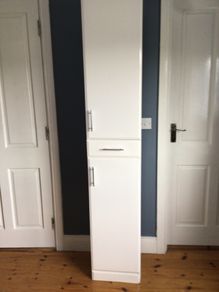 Tall white storage unit with drawer