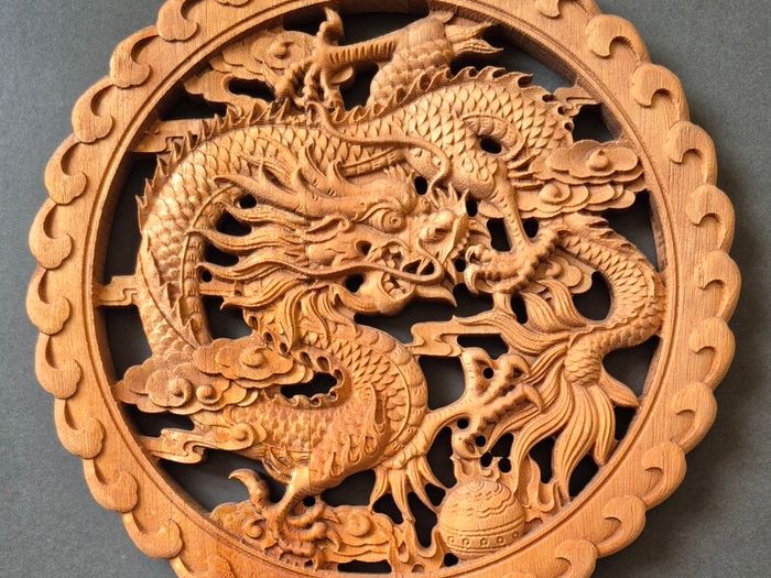 Carved decorative wooden plaque, featuring dragons.