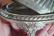 A vintage silver-plated butter dish or caviar bowl with a three-legged lid.