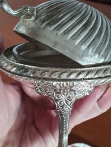 A vintage silver-plated butter dish or caviar bowl with a three-legged lid.