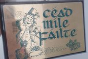 A vintage decorative wall plaque featuring a traditional Irish greeting.