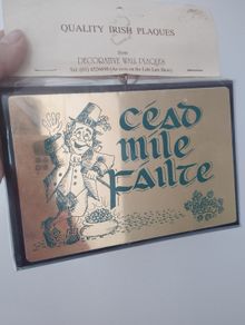 A vintage decorative wall plaque featuring a traditional Irish greeting.