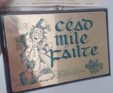 A vintage decorative wall plaque featuring a traditional Irish greeting.