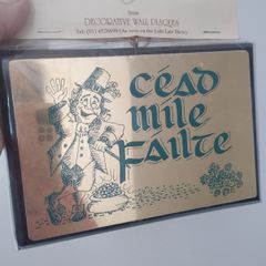 A vintage decorative wall plaque featuring a traditional Irish greeting.