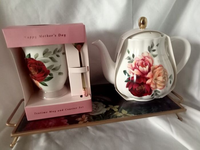 Gift set of a teapot, mug, spoon and coaster.